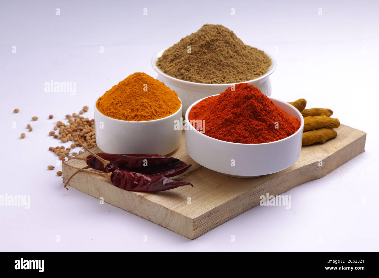 Indische Gewürze Chili, Kurkuma und Koriander sind die drei grundlegenden Gewürze für indische Curry oder Gerichte, in einer weißen Schüssel angeordnet Stockfoto