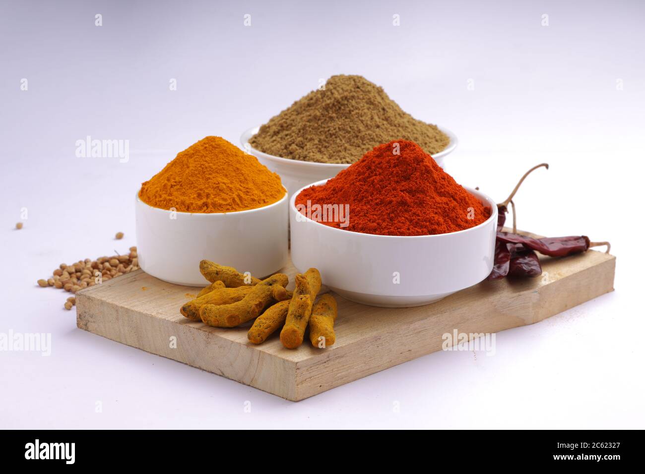 Indische Gewürze Chili, Kurkuma und Koriander sind die drei grundlegenden Gewürze für indische Curry oder Gerichte, in einer weißen Schüssel angeordnet Stockfoto