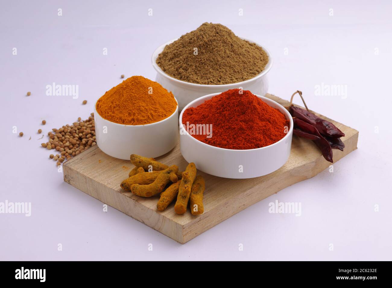 Indische Gewürze Chili, Kurkuma und Koriander sind die drei grundlegenden Gewürze für indische Curry oder Gerichte, in einer weißen Schüssel angeordnet Stockfoto