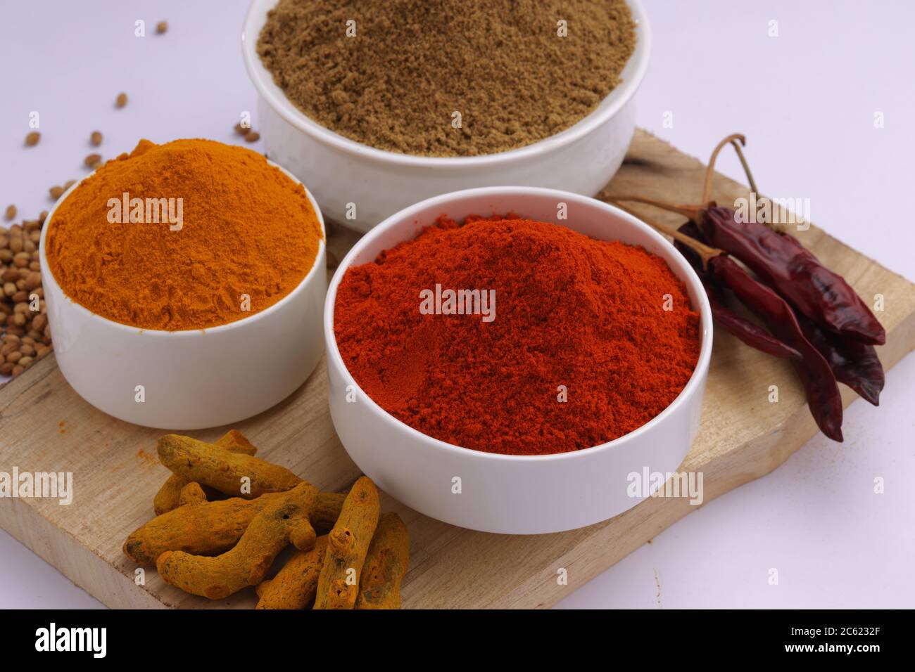 Nahaufnahme der indischen Gewürze Chili, Kurkuma und Koriander sind die drei grundlegenden Gewürze für indische Curry oder Gerichte, in weißen Schalen angeordnet Stockfoto