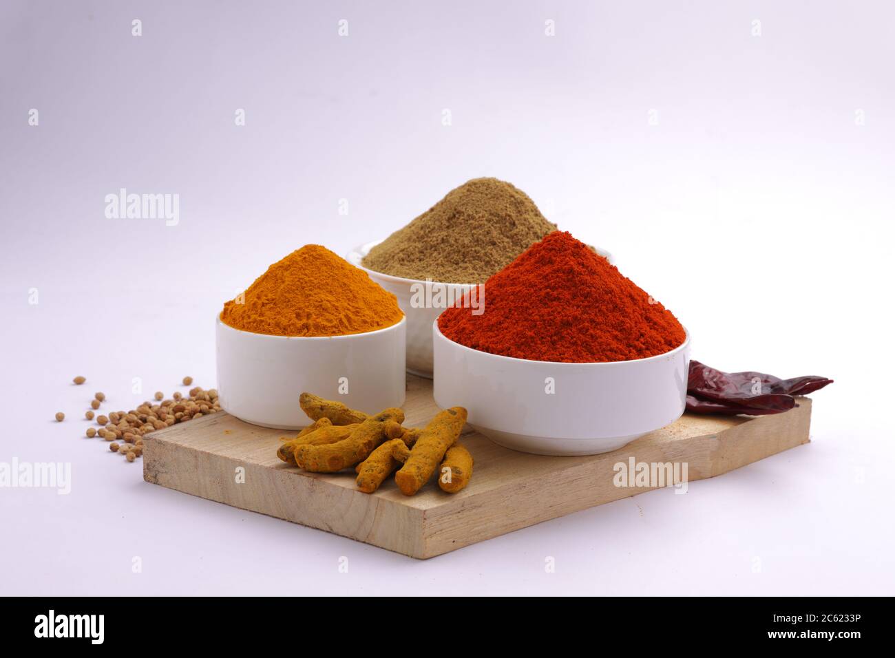 Indische Gewürze Chili, Kurkuma und Koriander sind die drei grundlegenden Gewürze für indische Curry oder Gerichte, in einer weißen Schüssel angeordnet Stockfoto