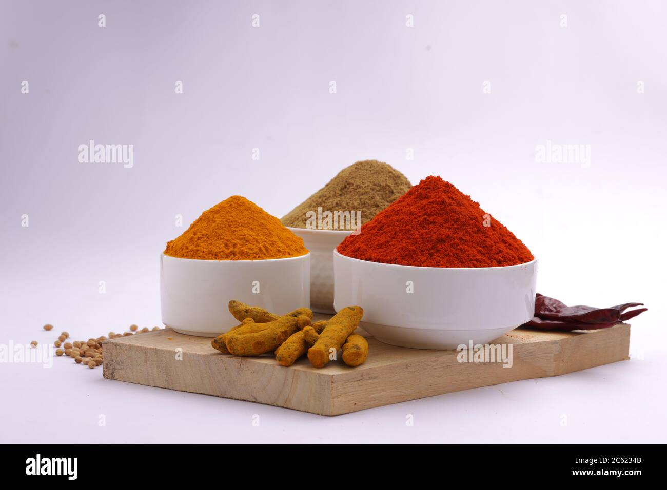 Indische Gewürze Chili, Kurkuma und Koriander sind die drei grundlegenden Gewürze für indische Curry oder Gerichte, in einer weißen Schüssel angeordnet Stockfoto