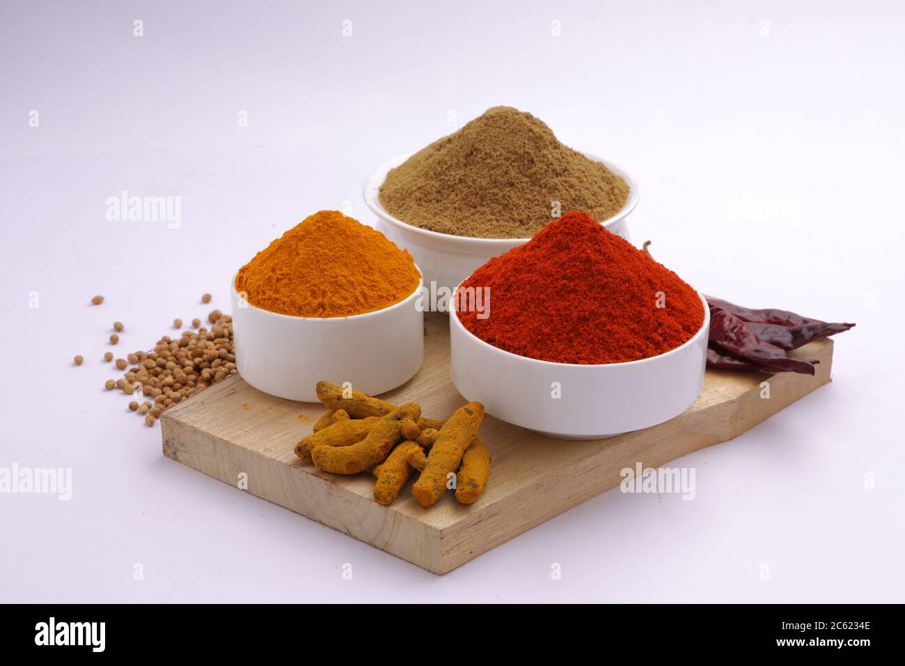 Indische Gewürze Chili, Kurkuma und Koriander sind die drei grundlegenden Gewürze für indische Curry oder Gerichte, in einer weißen Schüssel angeordnet Stockfoto