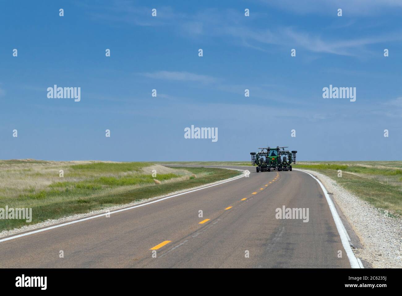 Schwere Landmaschinen, die auf der Autobahn, Ness City Kansas, USA, gefahren werden Stockfoto