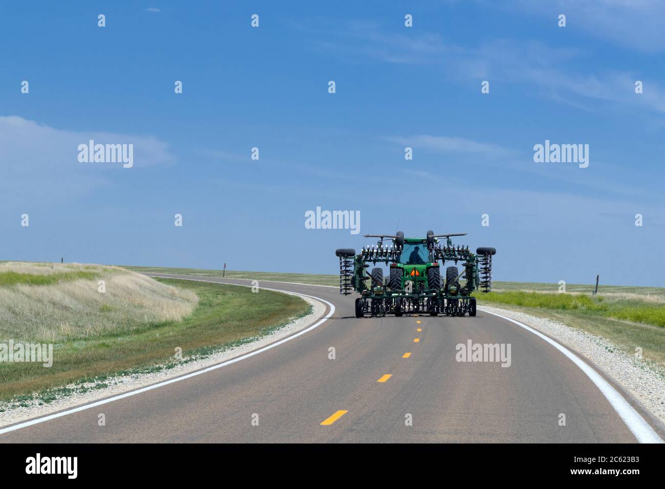 Schwere Landmaschinen, die auf der Autobahn, Ness City Kansas, USA, gefahren werden Stockfoto