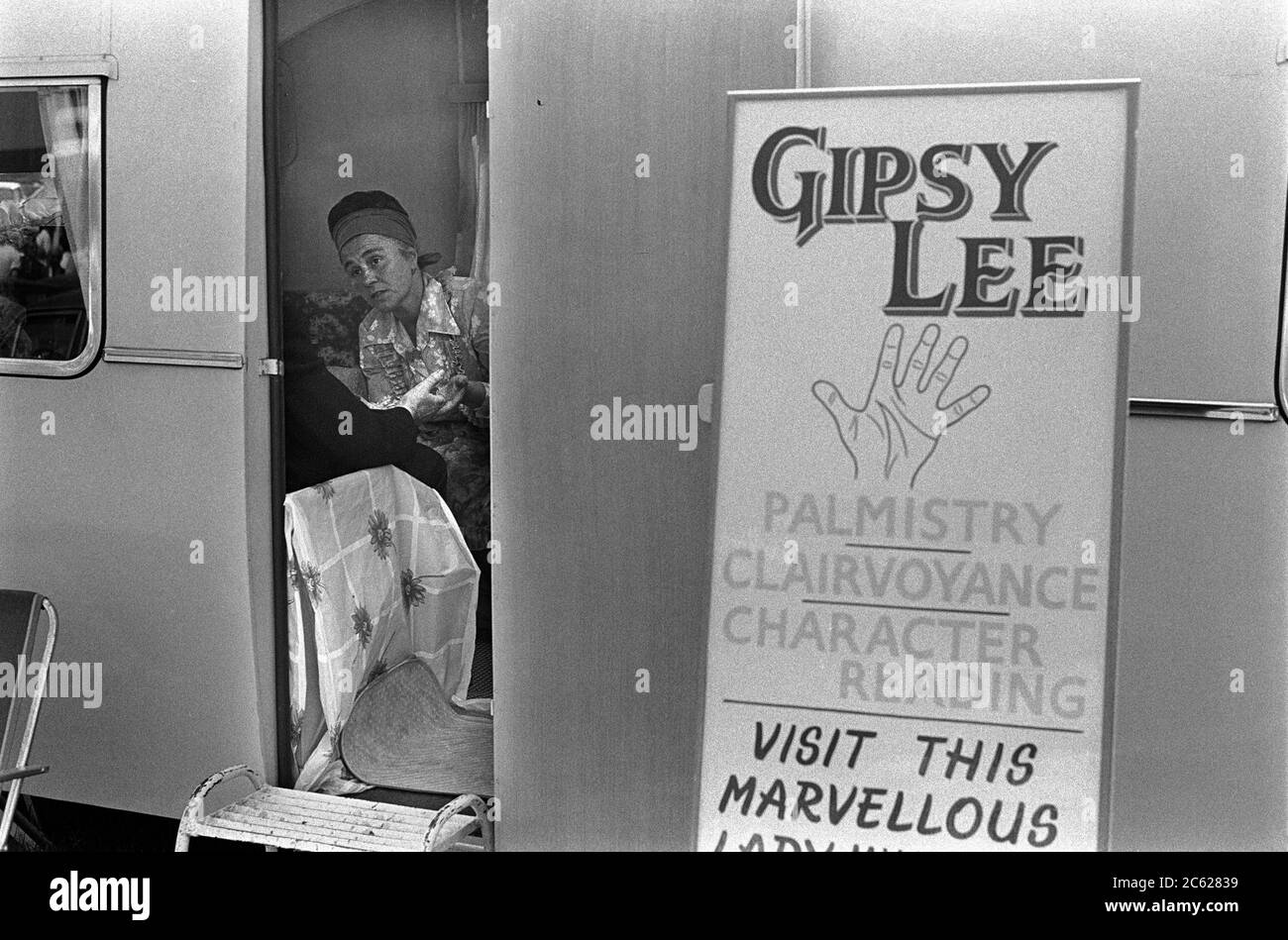 Gipsy Fortune Teller 70er Jahre Großbritannien. Gipsy Lee liest die Handfläche eines Kunden. Palmistry, Hellsehen und Charakterlesungen. Beim Derby Day Pferderennen treffen. On the Hill, Epsom Downs, Surrey 1974. UK HOMER SYKES Stockfoto