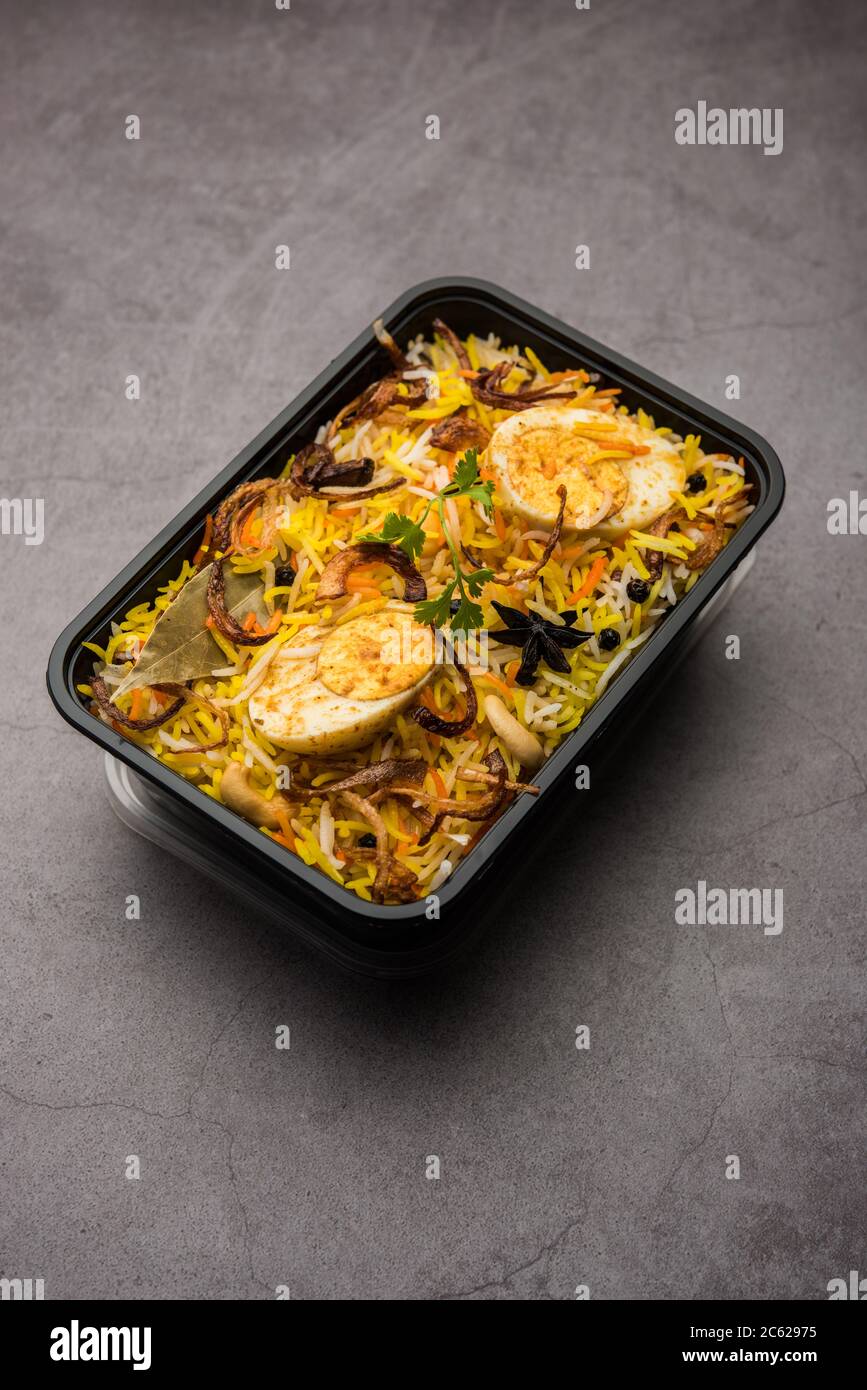 Restaurant Stil Ei Biryani oder Anda Pulao verpackt für die Hauslieferung in Plastikbox oder Container mit Raita und Salan Stockfoto