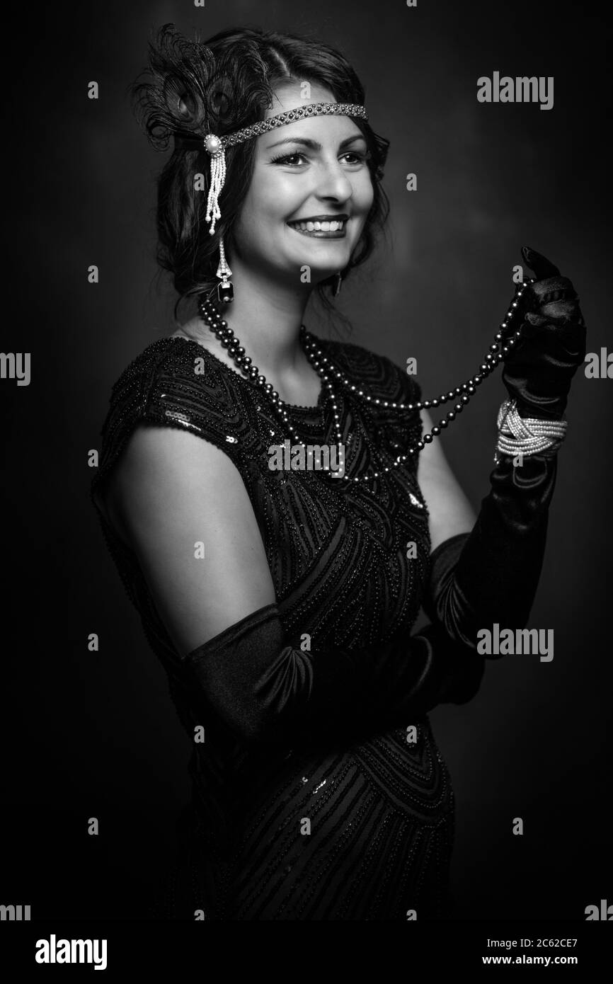 Elegante junge Dame Lächeln mit Perle Halskette 1920er Jahre schwarz und weiß Stockfoto