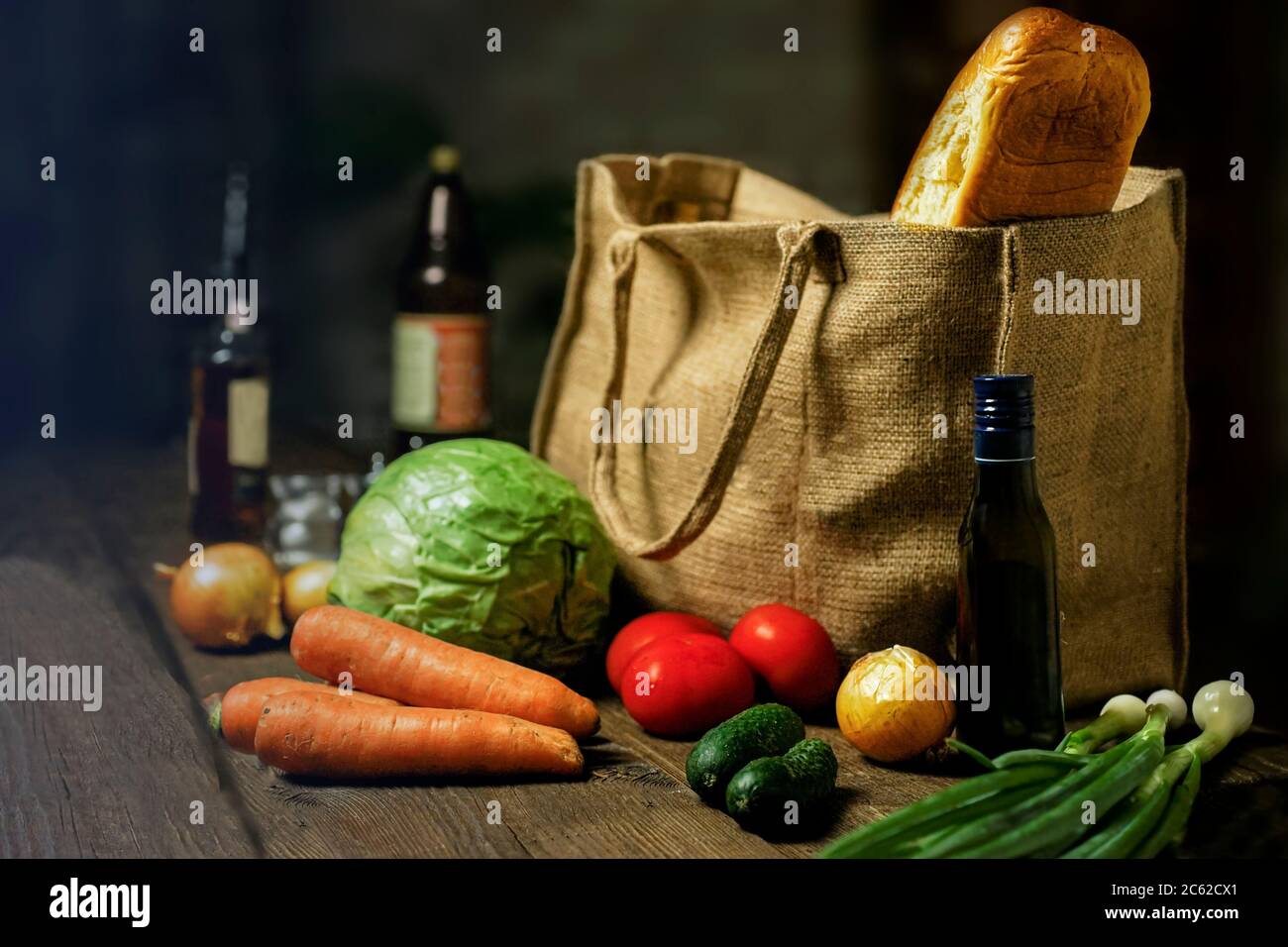 Öko-Beutel aus Naturburlap mit Lebensmitteln und Gemüse steht auf einem Holztisch. Eco-Konzept. Stockfoto
