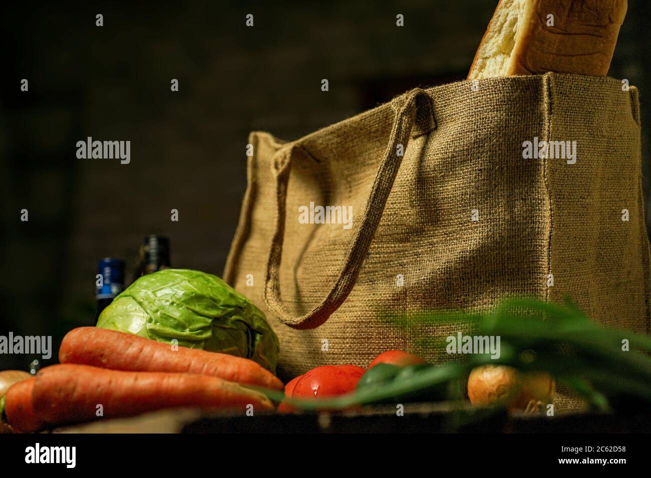 Öko-Beutel aus Naturburlap mit Lebensmitteln und Gemüse steht auf einem Holztisch. Eco-Konzept. Stockfoto
