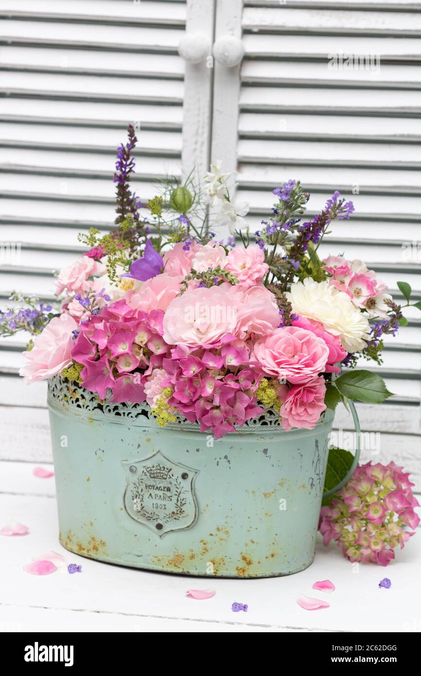 Romantisches Bouquet in rosa mit Sommerblumen im Vintage-Pflanzentopf Stockfoto