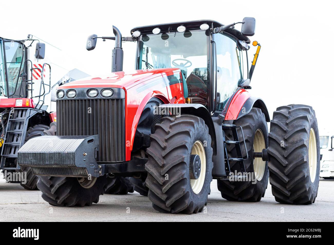 Großer landwirtschaftlicher Traktor auf weißem Hintergrund. Ausrüstung für die Kultivierung des Landes. Seitenansicht. Nahaufnahme. Stockfoto