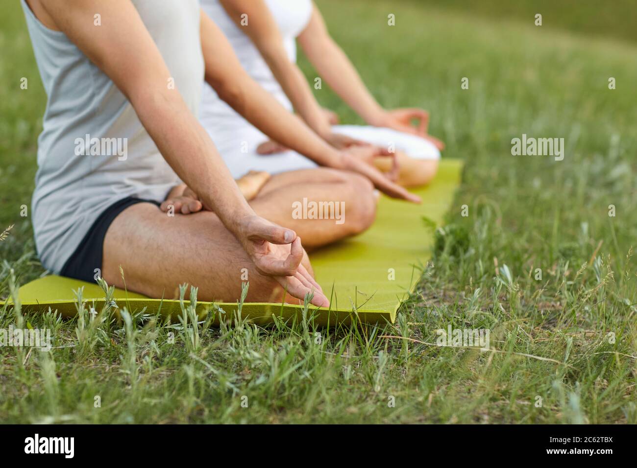 Yoga in der Natur. Nahaufnahme die Hände der Yogis Mann und Frau meditieren im Sommerpark. Stockfoto