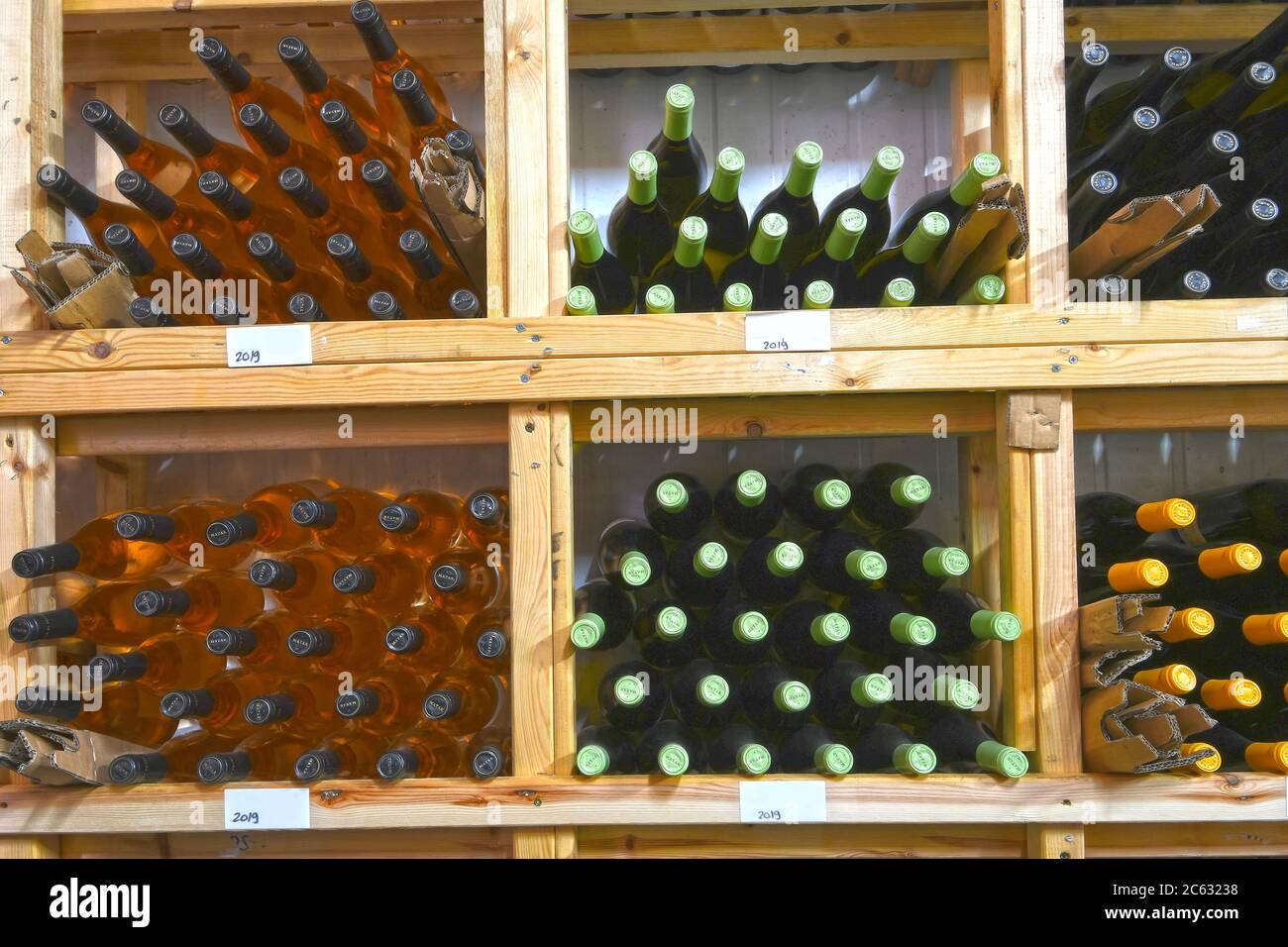 Verschiedene Weinflaschen auf einem Holzregal in einem Weingut gelagert Stockfoto