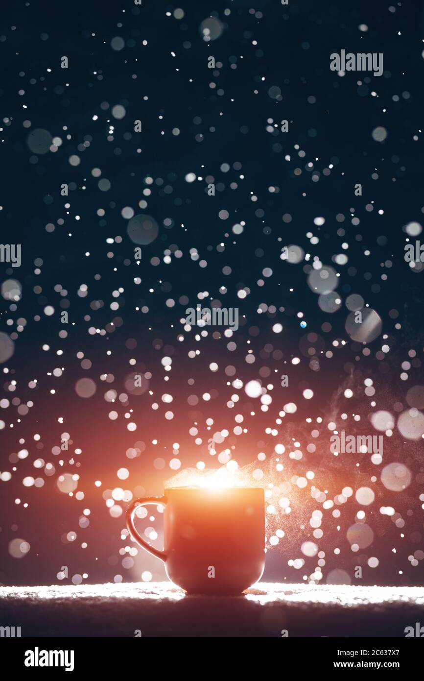 Hinterleuchtete Tasse heißen dampfenden Kaffee trinken oder Tee auf Nacht verschneiten Hintergrund Stockfoto