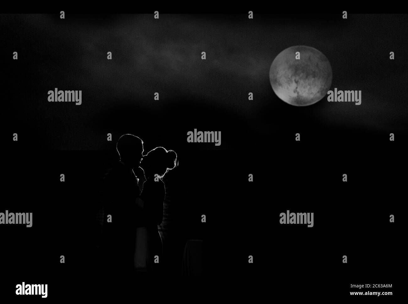 Silhouette von Braut und Bräutigam küssen mit einem Vollmond im Hintergrund Stockfoto