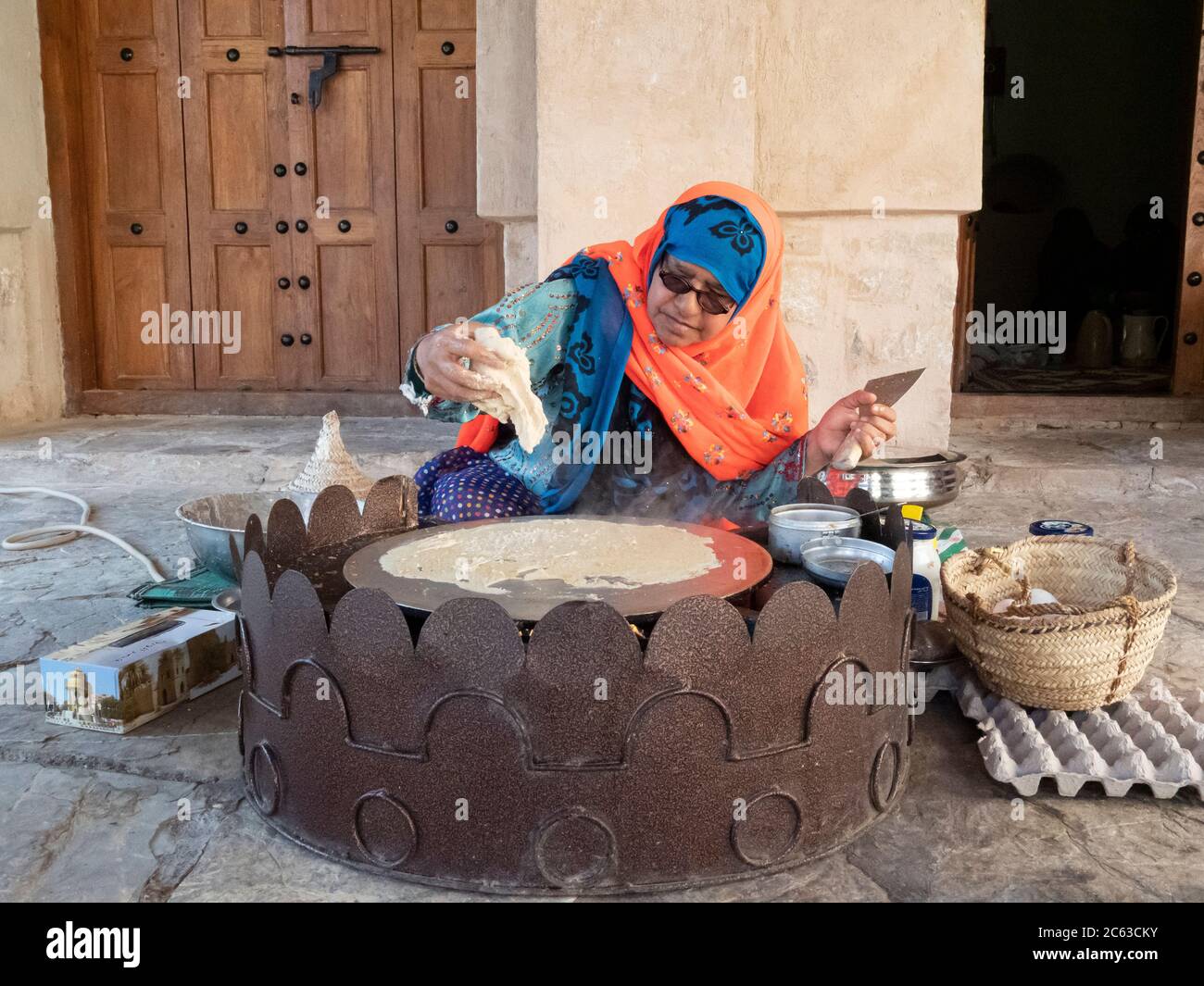 Frau, die ein traditionelles omanisches Frühstück im Nizwa Fort, Nizwa, Sultanat von Oman zubereitet. Stockfoto