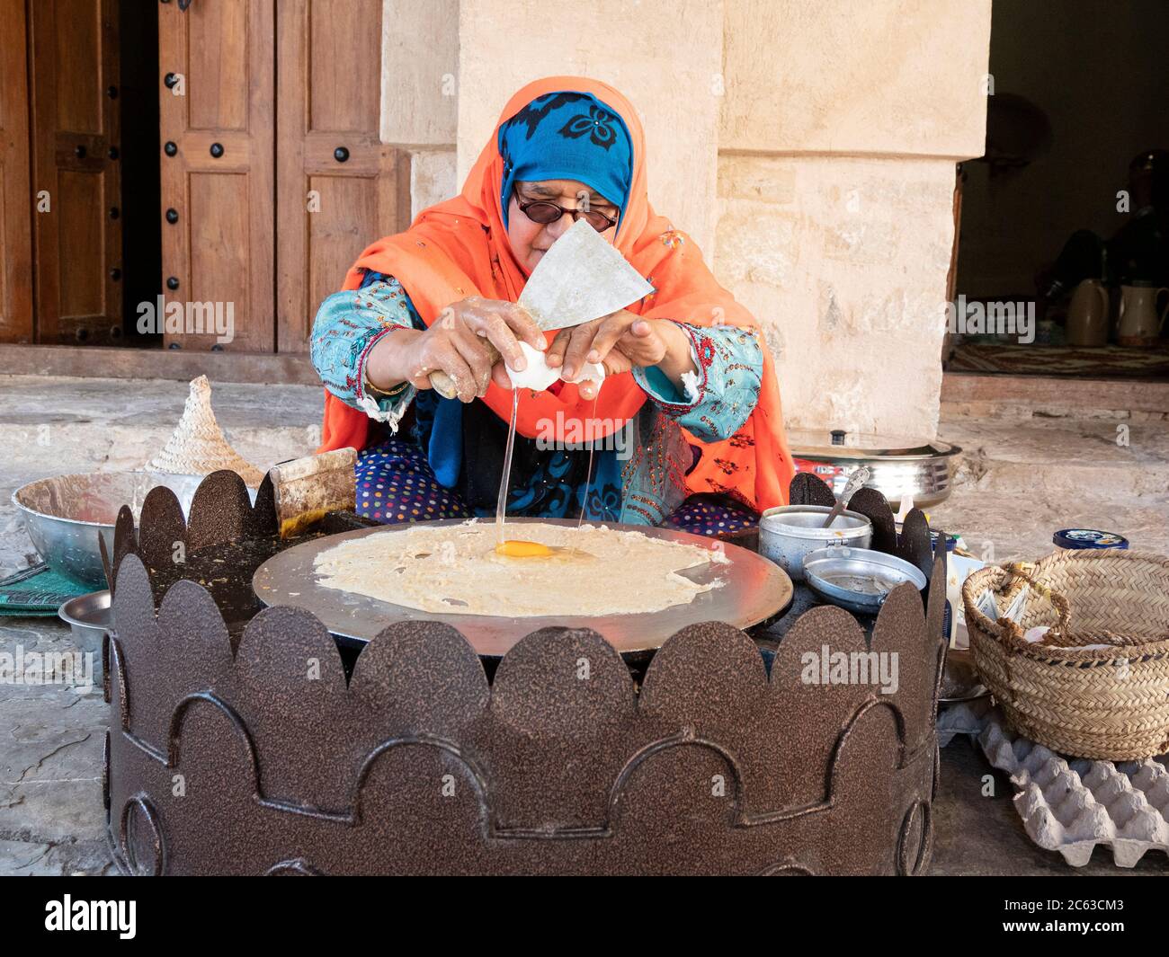 Frau, die ein traditionelles omanisches Frühstück im Nizwa Fort, Nizwa, Sultanat von Oman zubereitet. Stockfoto