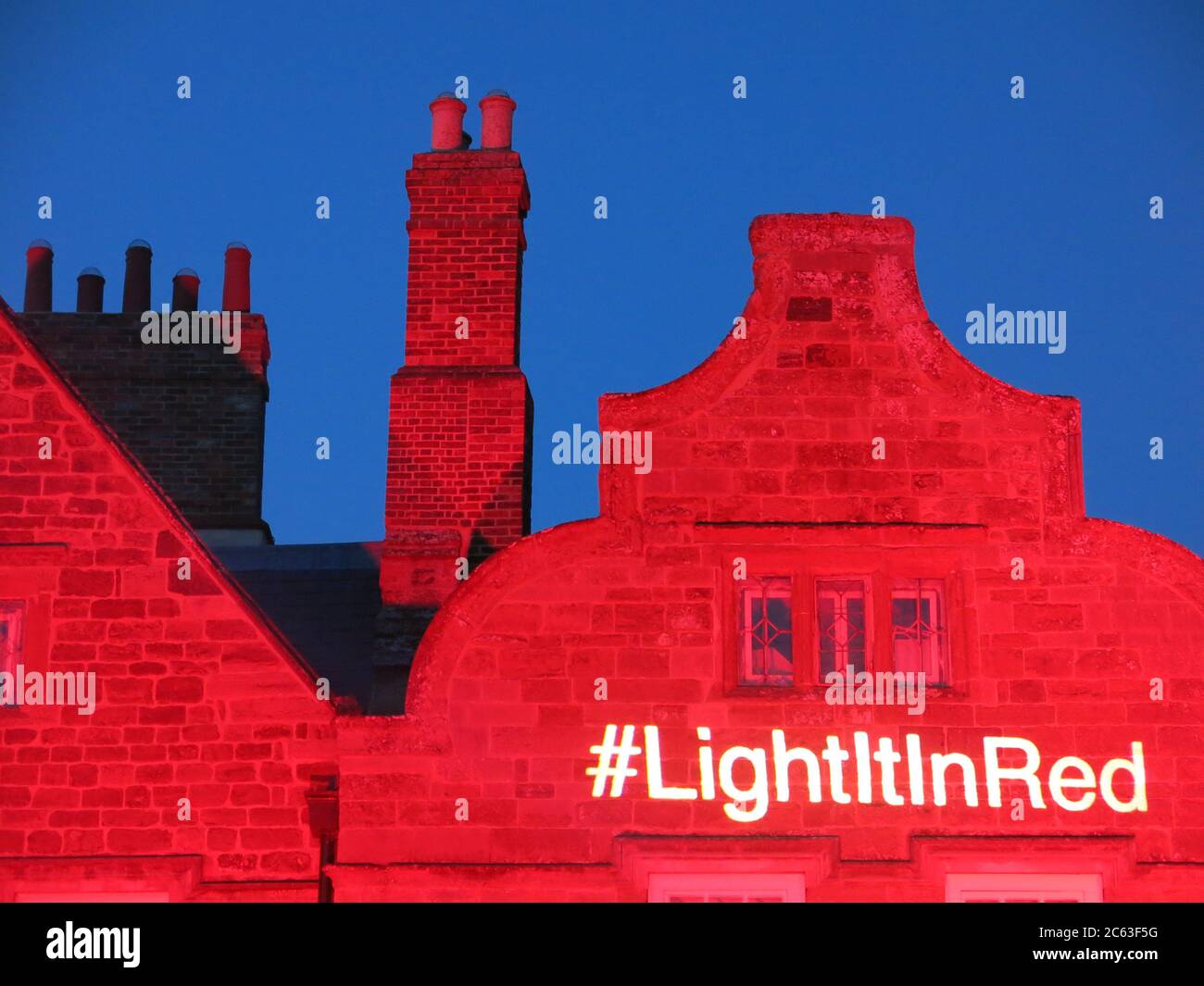 Foto des Slogans # Light IT in Red am 6. Juli 2020 in der Delapre Abbey in Northampton, wo die Dachlinie im Rahmen einer nationalen Kampagne beleuchtet wird. Stockfoto