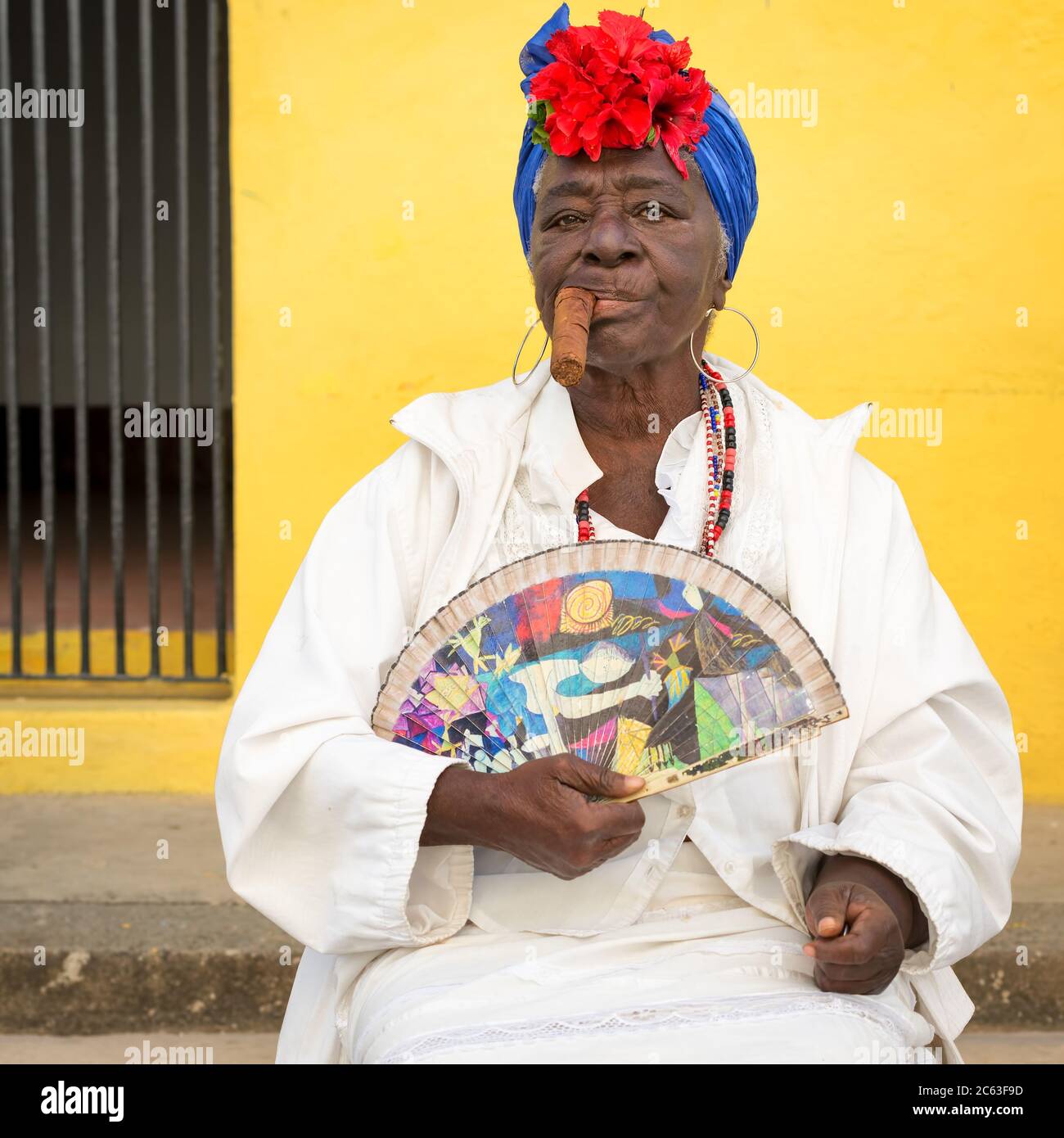 Alte schwarze Frau, die in der Altstadt von Havanna eine riesige kubanische Zigarre raucht Stockfoto