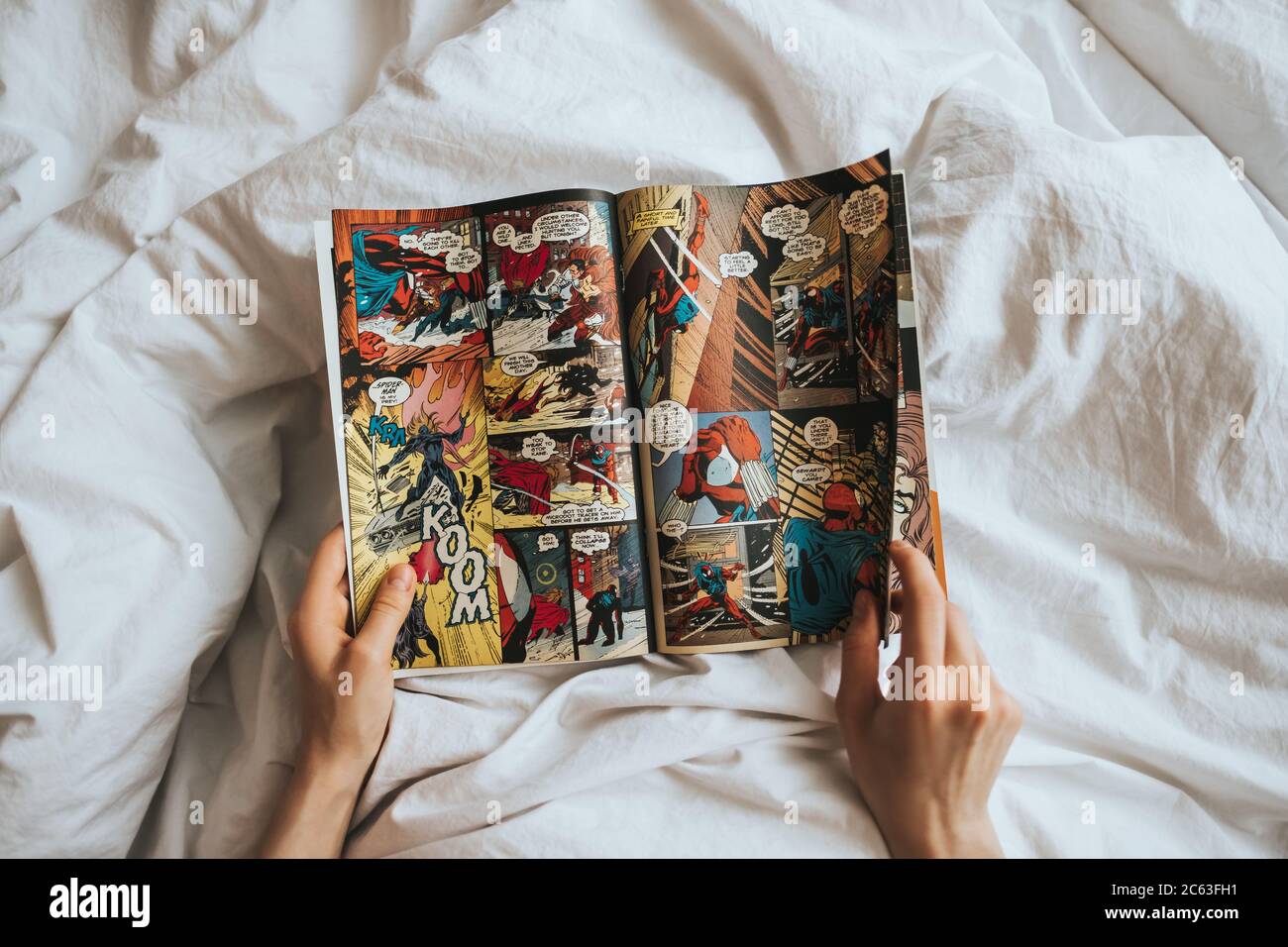 Frau liest Comics im Bett. Stockfoto