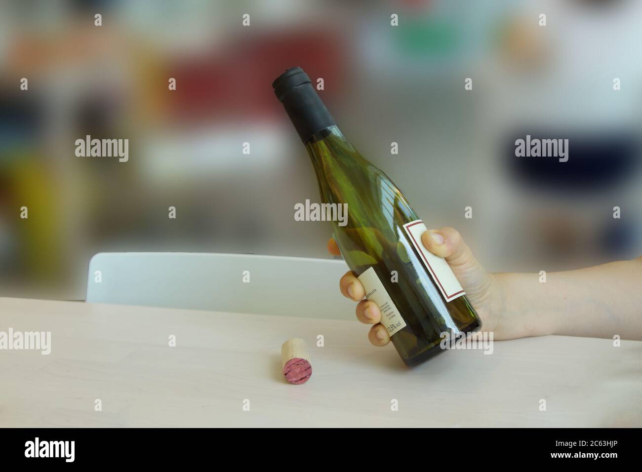 Frau Hand hält eine Flasche, während Wein gießt Stockfoto