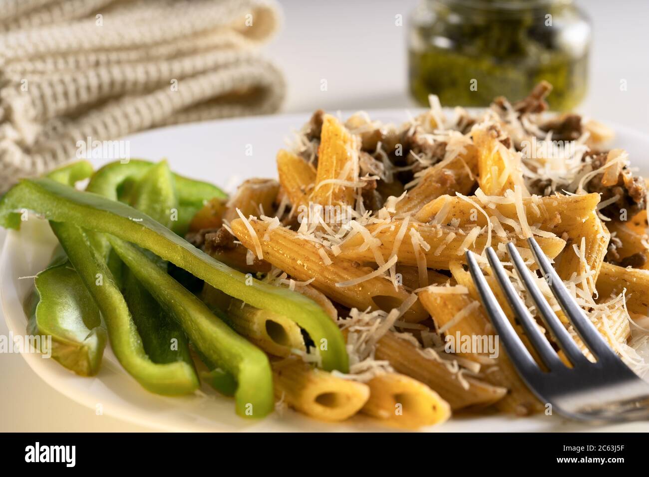 Köstliche Gourmet-Pasta mit Fleisch- und Gemüsedressing auf weißem Teller. Stockfoto