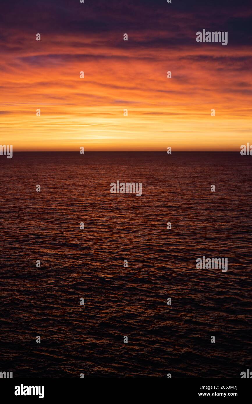 Orange und rosa Wolken über dem Ozeanhorizont Stockfoto