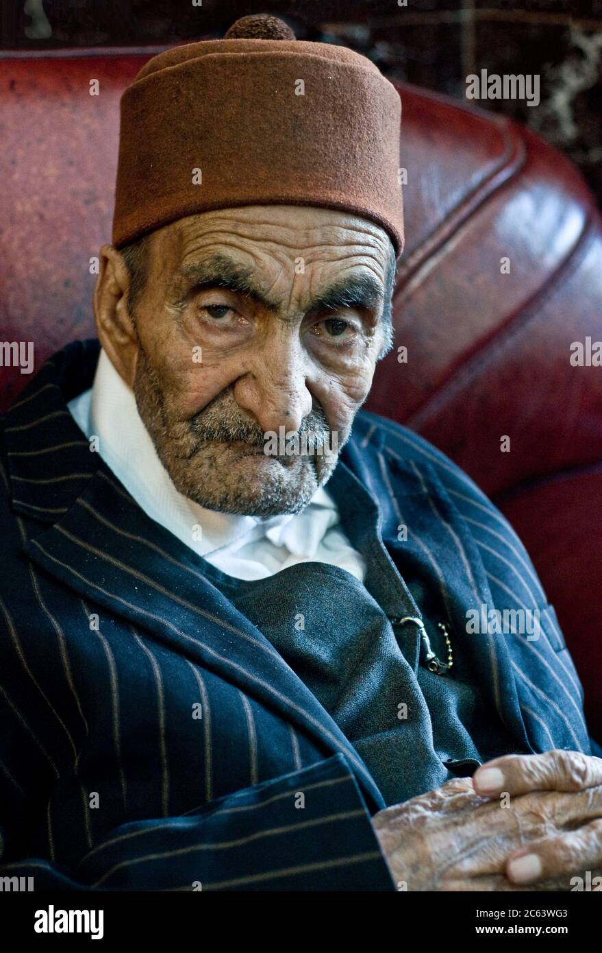 Ein älterer kurdischer Mann mit rotem Filzhut und Nadelstreifenanzug in der Stadt Dogubeyazit in der östlichen Region Anatoliens der Türkei. Stockfoto