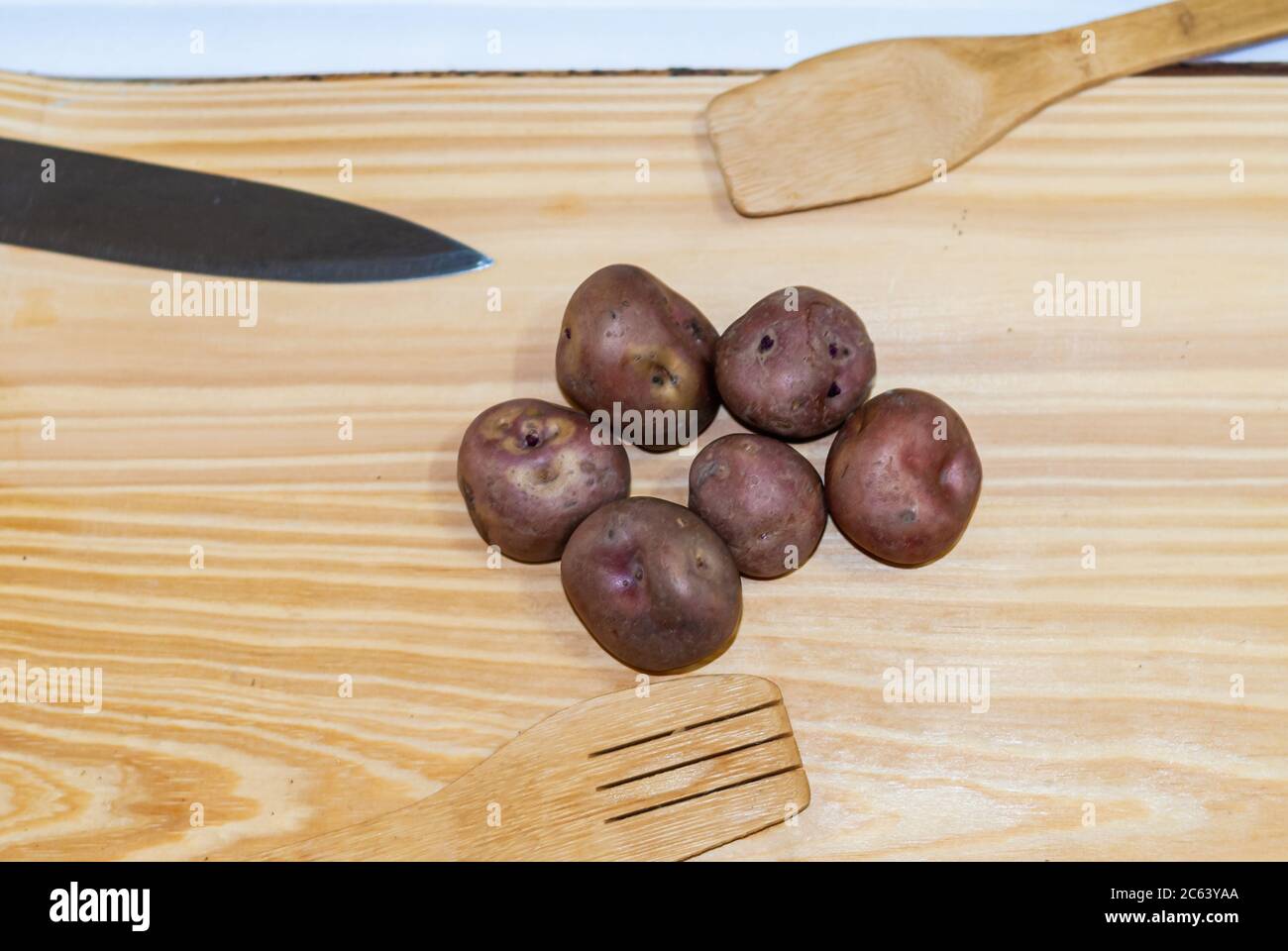 Regionale Kartoffeln aus den Anden auf einem Markt in Peru, Bolivien, Argentinien, Südamerika auf einem Holztisch. Selektiver Fokus Stockfoto