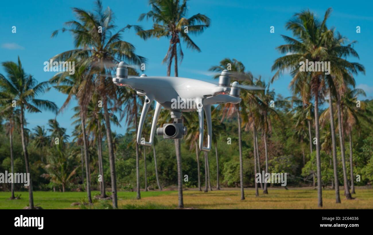 El Nido, Philippinen - 7. Februar 2019: Hubschrauber mit professioneller Kamera fliegt vor dem Hintergrund tropischer Bäume. Stockfoto