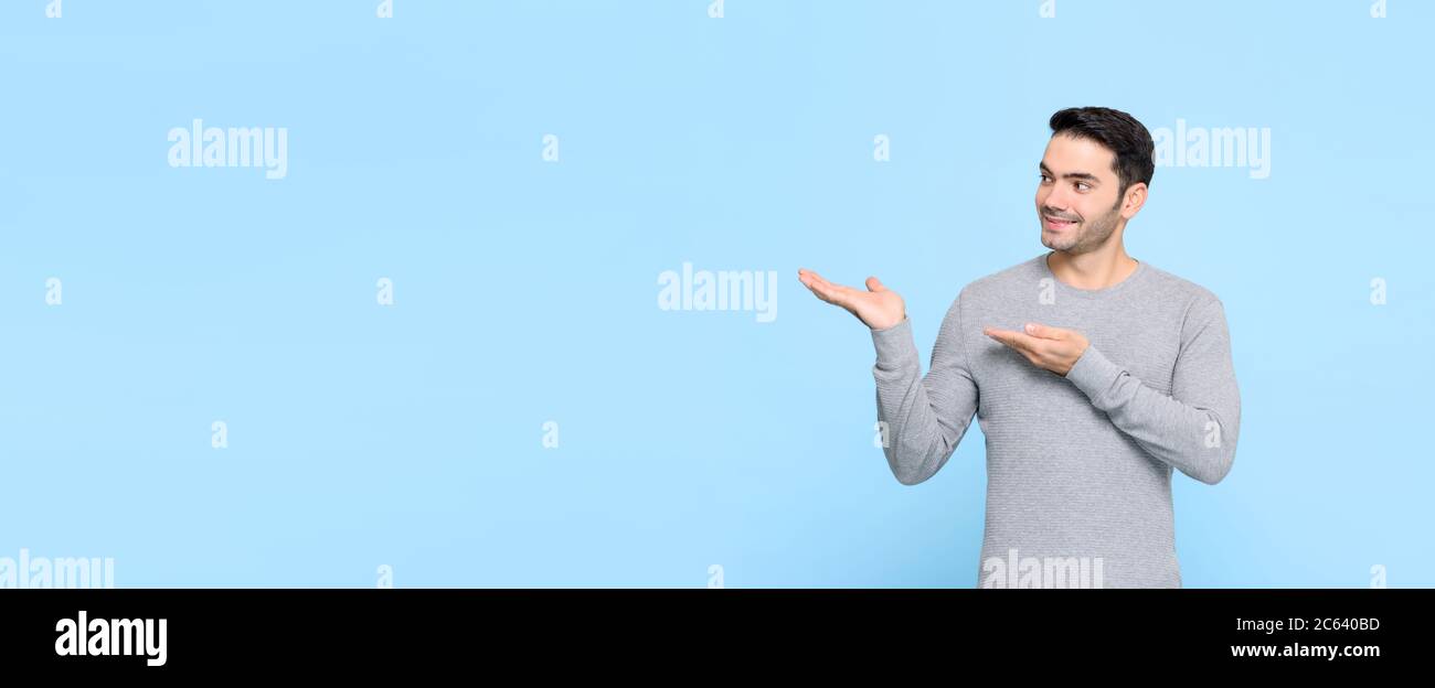 Junge gut aussehende kaukasischen Mann mit Händen öffnen, um Platz beiseite auf isolierten hellblauen Banner Hintergrund kopieren Stockfoto