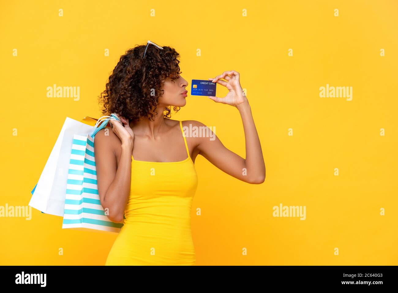 Modische lockiges Haar Frau mit Einkaufstaschen liebt es, mit Kreditkarte verbringen Stockfoto