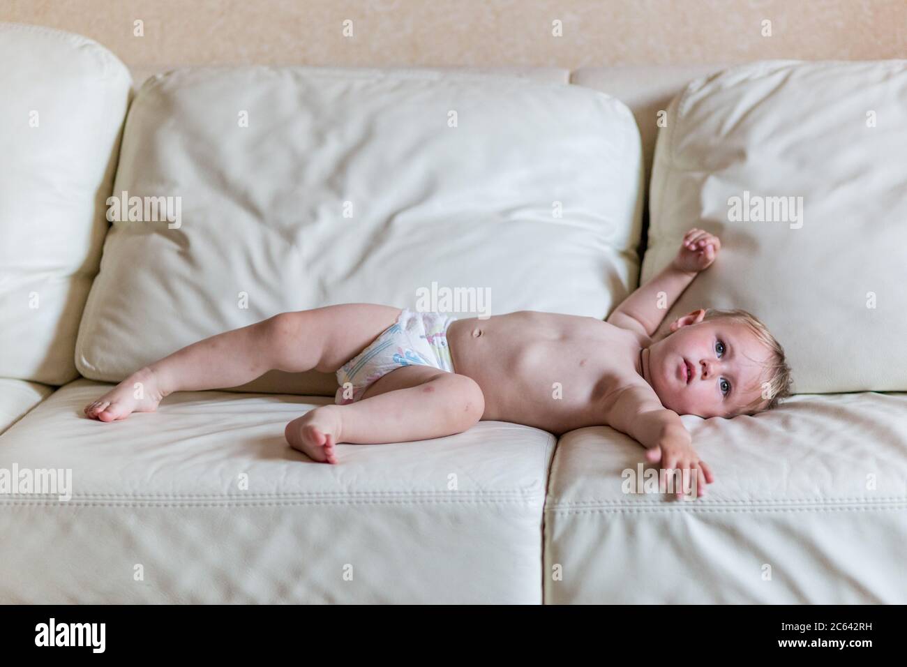 Nettes Baby Mädchen in Windeln auf dem Bett liegen Stockfotografie - Alamy