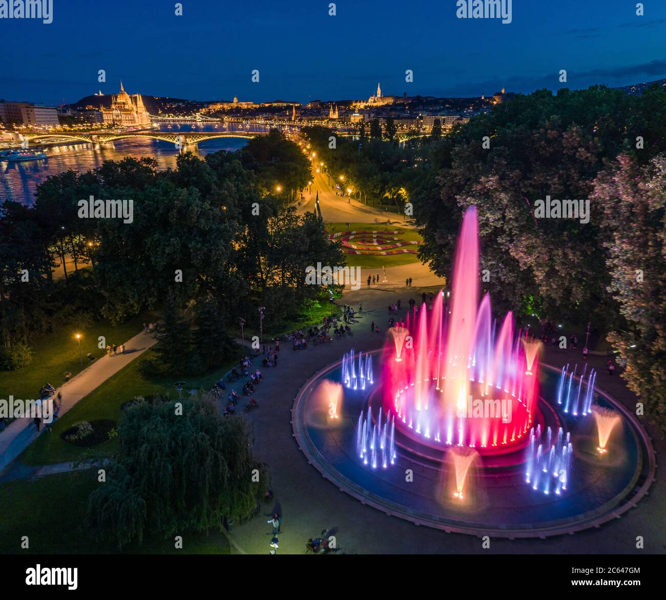 Budapest, Ungarn - Luftaufnahme des Margareteninsel Musikbrunnens in der Abenddämmerung mit Parlamentsgebäude, Fischerbastei und Budaer Burg Royal Pa Stockfoto