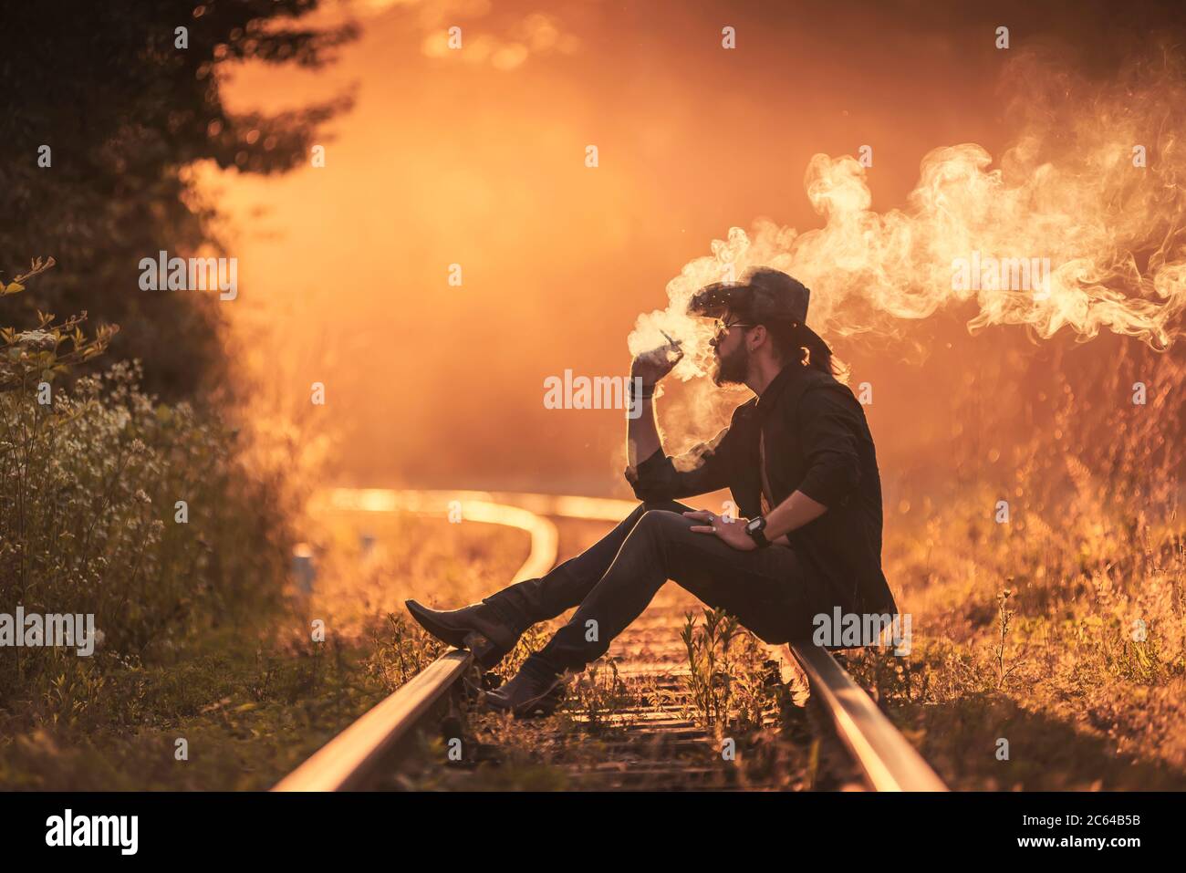 Cowboy raucht eine Zigarette auf der Bahnlinie Stockfoto