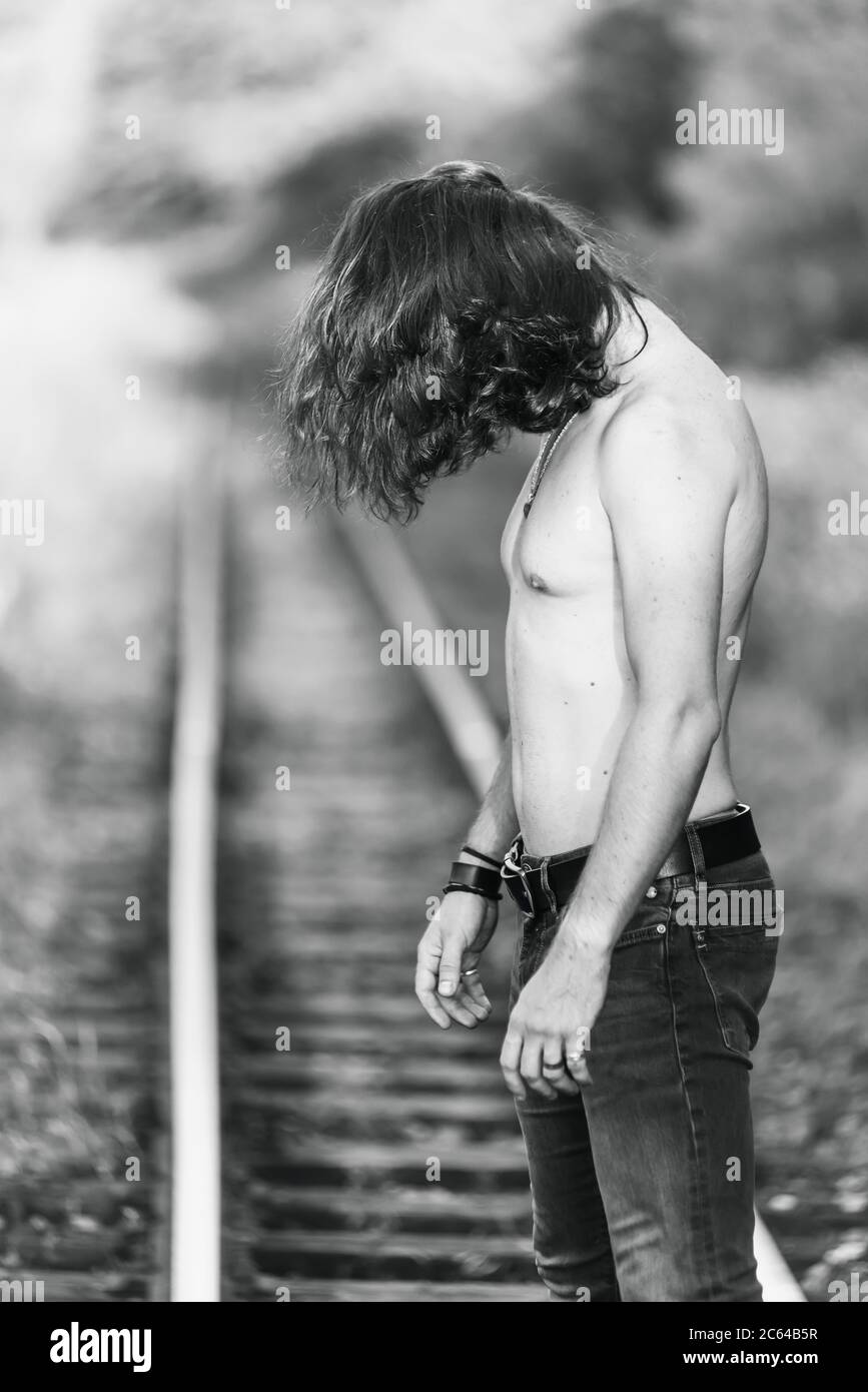 Depressiver Mann auf einer Eisenbahnlinie Stockfoto