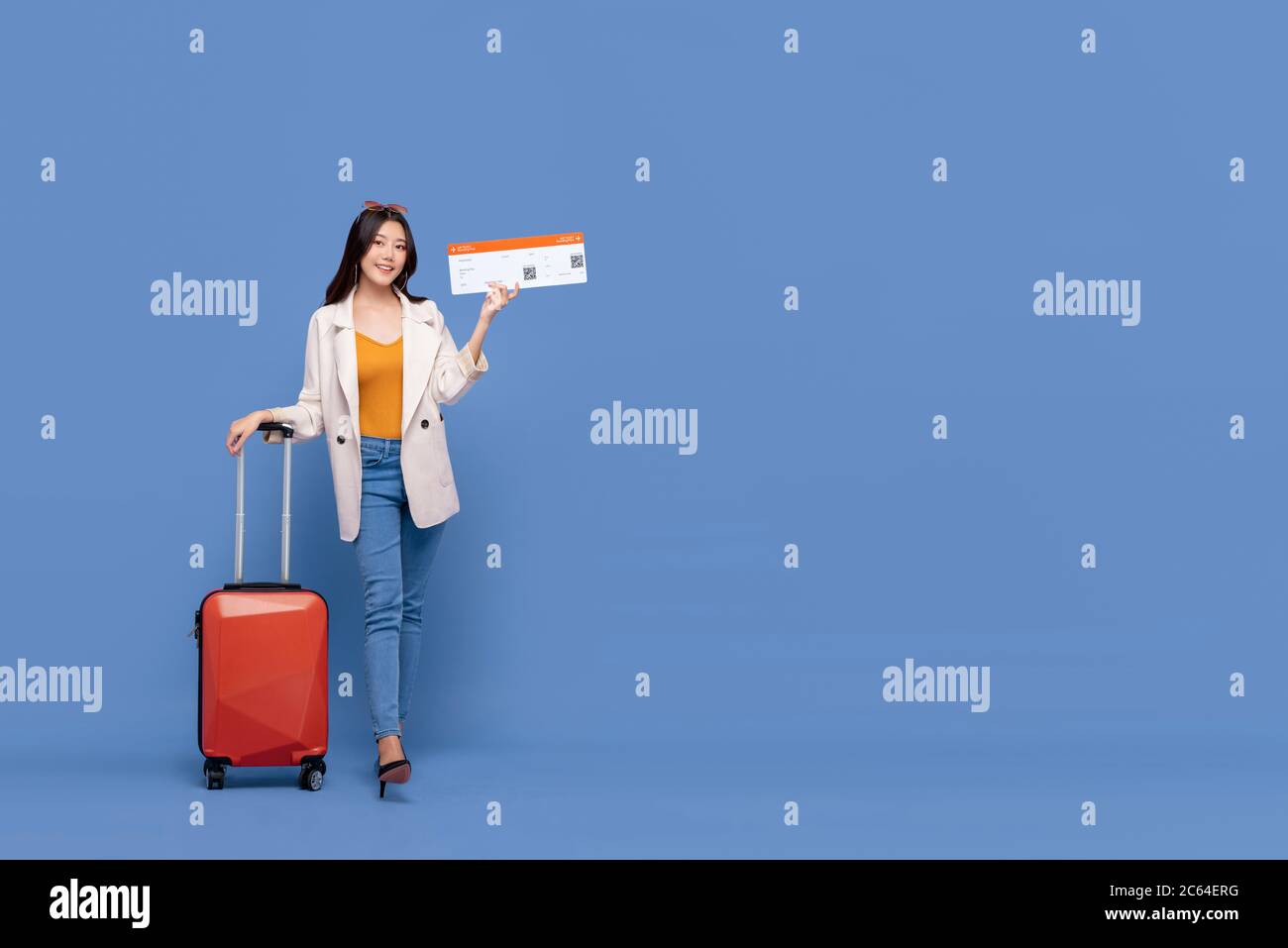Ganzer Körper von schönen jungen asiatischen Frau Tourist mit Gepäck zeigt Bordkarte bereit für die Reise isoliert auf blauem Hintergrund mit Kopieplatz Stockfoto