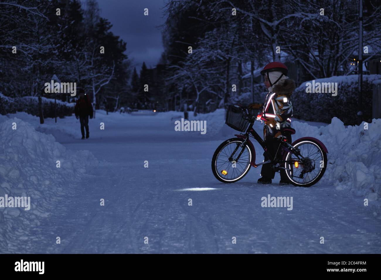 Kinder auf dem Fahrrad in einem Winterabend. Das Licht wird von Reflektoren  der Kleidung reflektiert. Sicheres Radfahren in der dunklen Zeit  Stockfotografie - Alamy
