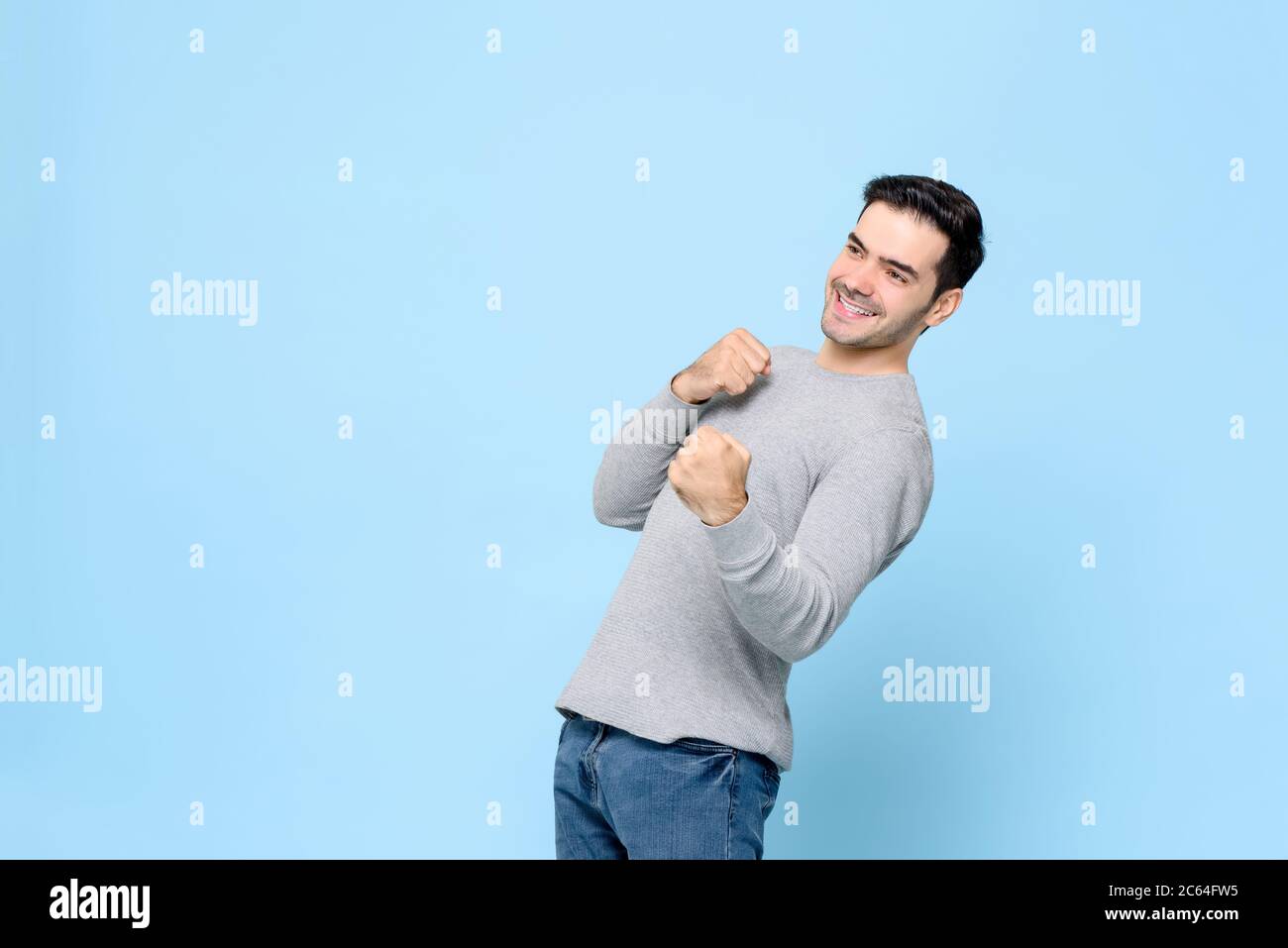 Erfreut gewinnenden kaukasischen Mann tun Faust Stanzen Geste isoliert auf hellblauem Hintergrund Stockfoto