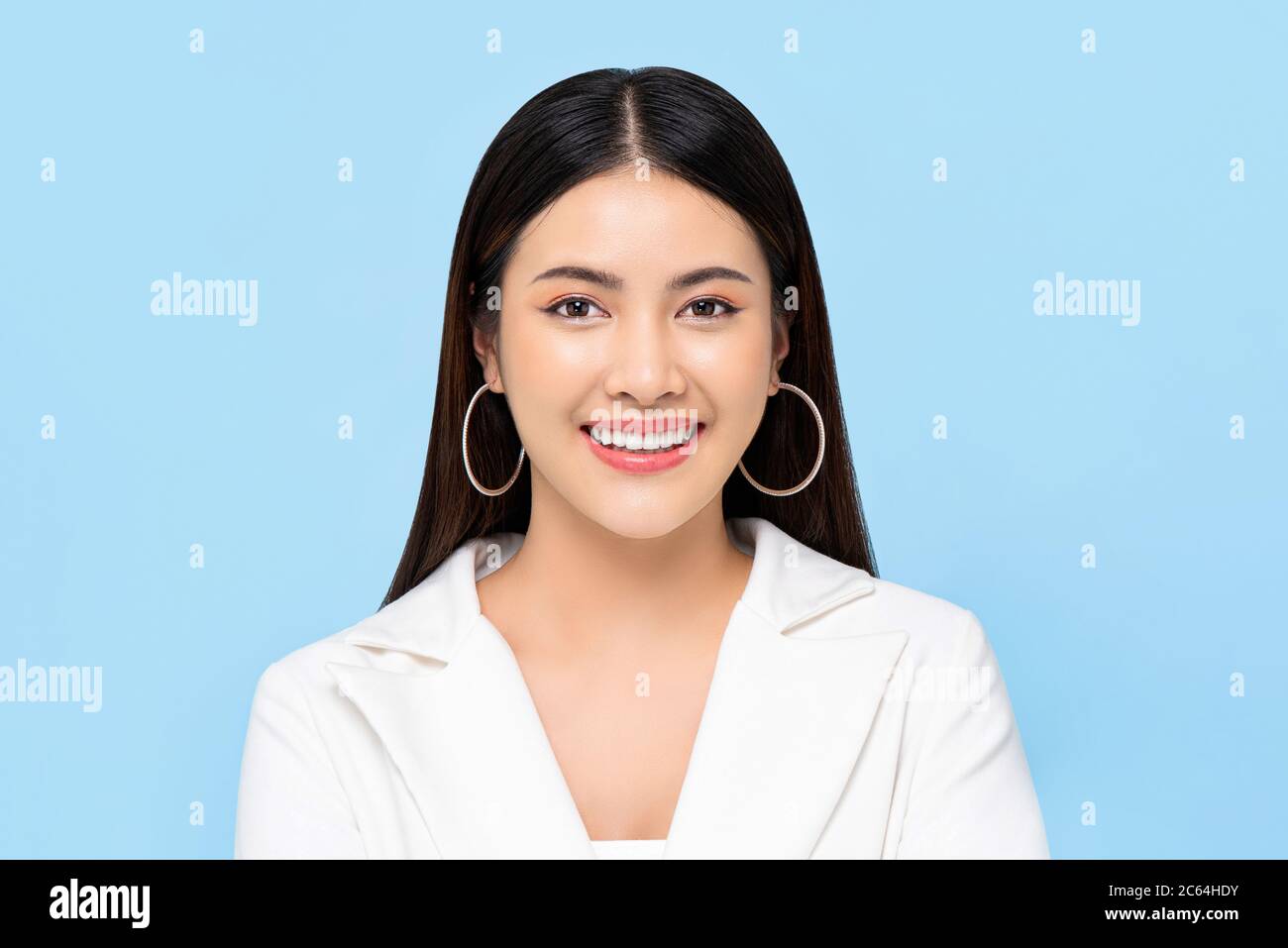 Beauty-Porträt von glücklich zuversichtlich lächelnde asiatische Frau mit klaren hellen Haut in isolierten hellblauen Hintergrund Stockfoto