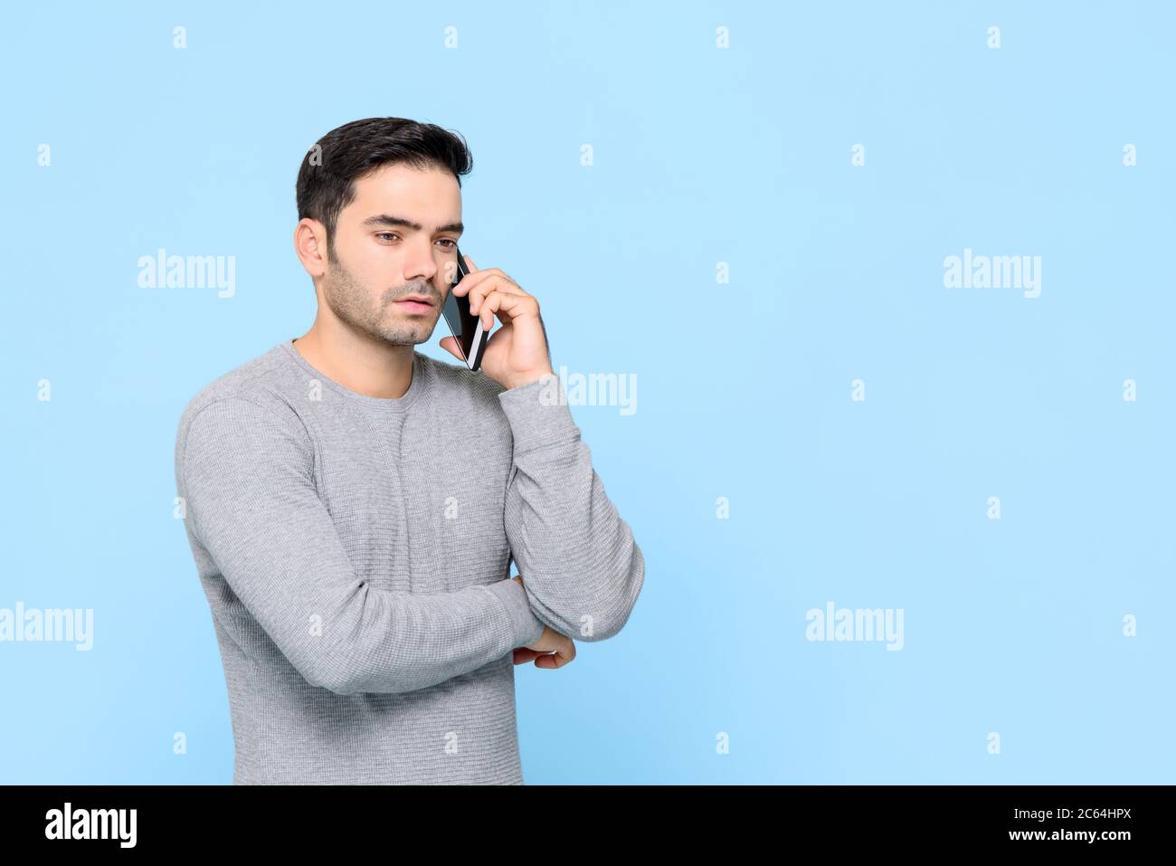 Porträt von schweren gut aussehenden kaukasischen Mann mit Gespräch am Telefon in isolierten Studio blauen Hintergrund Stockfoto