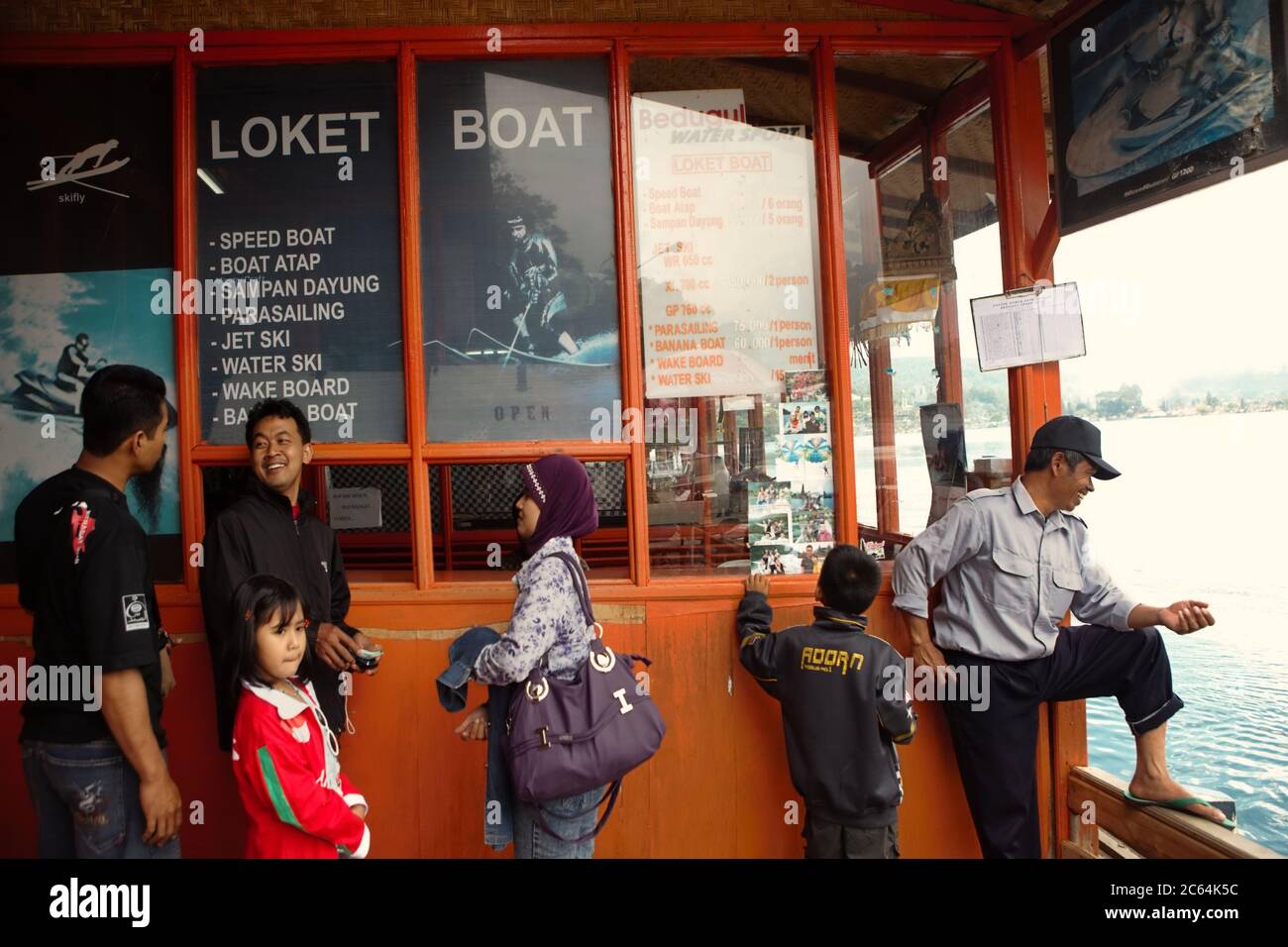 Lokale Touristen an einem Ticketschalter für Freizeit-Wassersport in Bedugul, Bali, Indonesien. Stockfoto