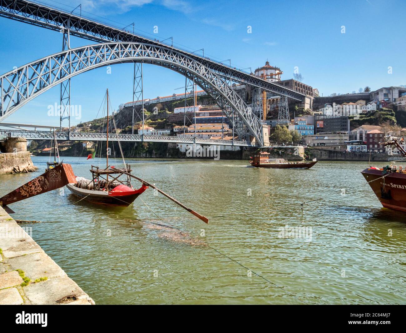 10. März 2020: Porto, Portugal - die Luis I Brücke, eine Straße und Bahnübergang des Douro Flusses in Porto, mit traditionell gestalteten Booten. Stockfoto