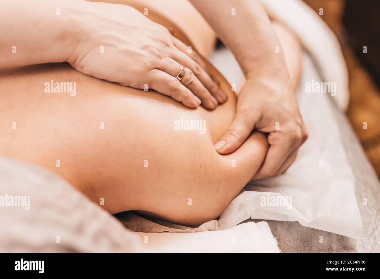 Behandlung von Schmerzen und Muskelkrämpfen in der Schulter - Sporttraumatologie - medizinische Massage Stockfoto