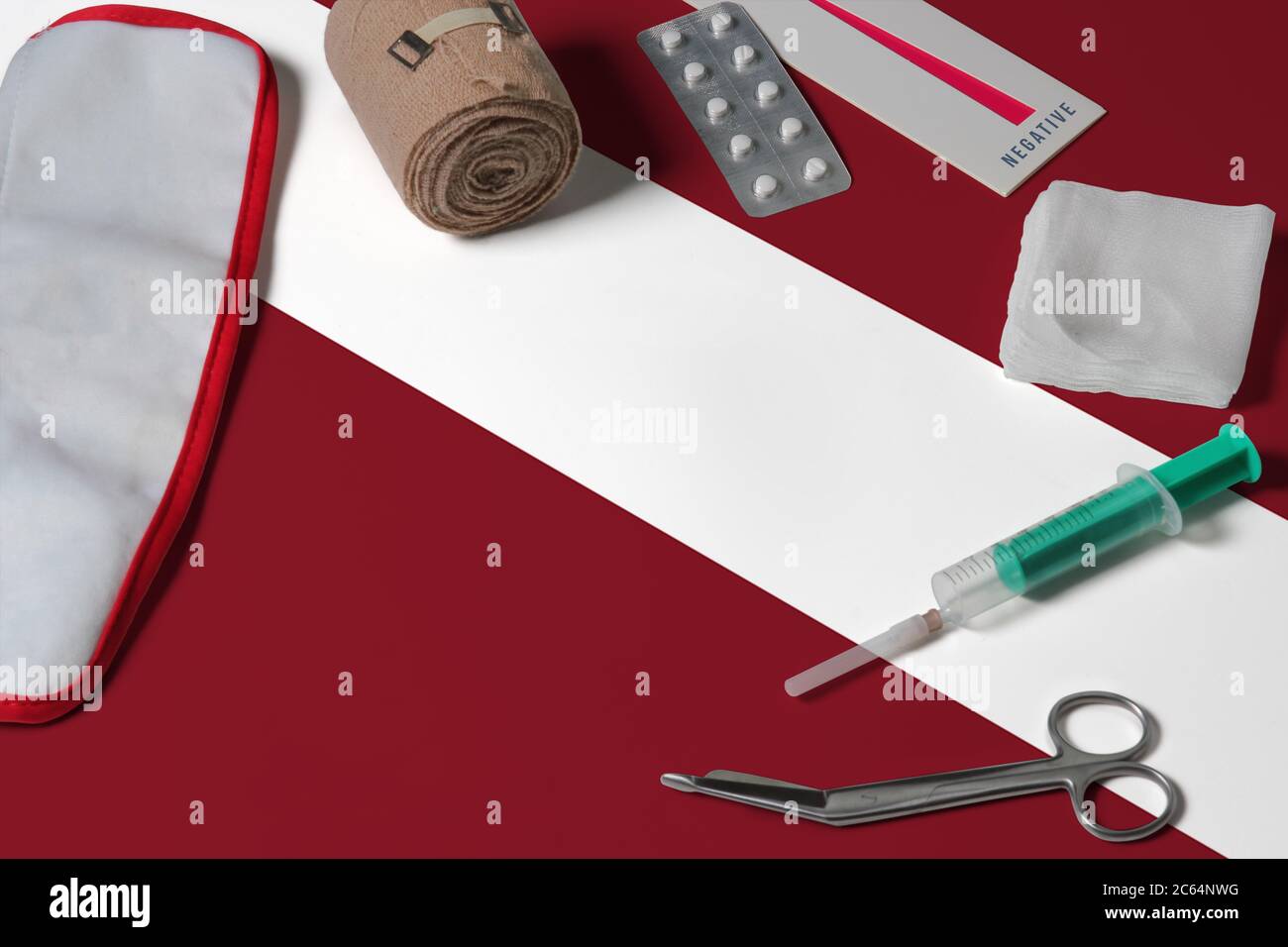 Lettland Flagge mit erste-Hilfe-medizinische Ausrüstung auf Holztisch Hintergrund. Nationales Gesundheitssystem Konzept, medizinisches Thema. Stockfoto