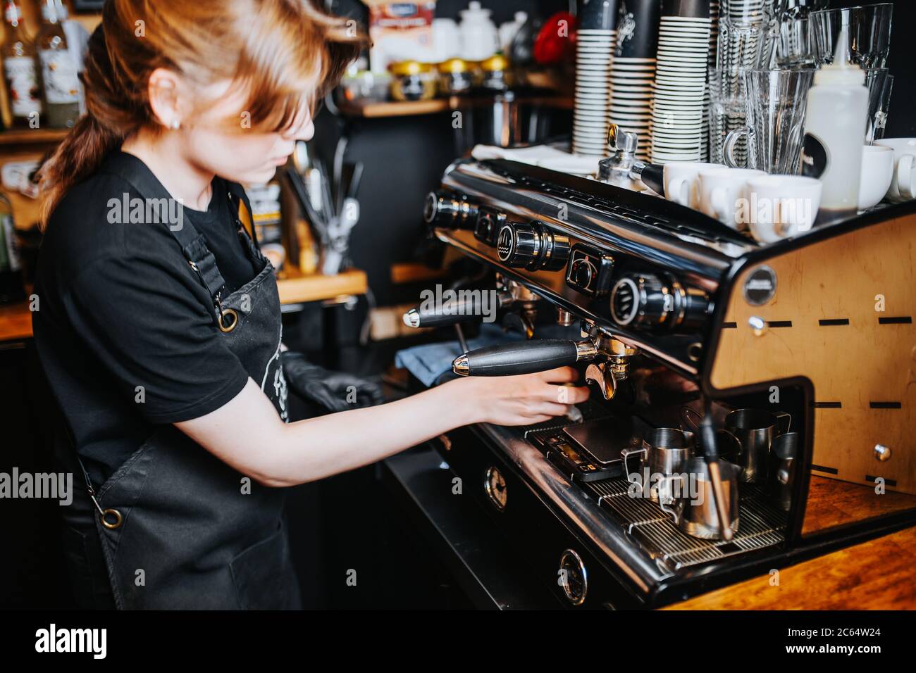 Barista Mädchen macht Espresso in einem Café - professionelle Kaffeemaschine Stockfoto