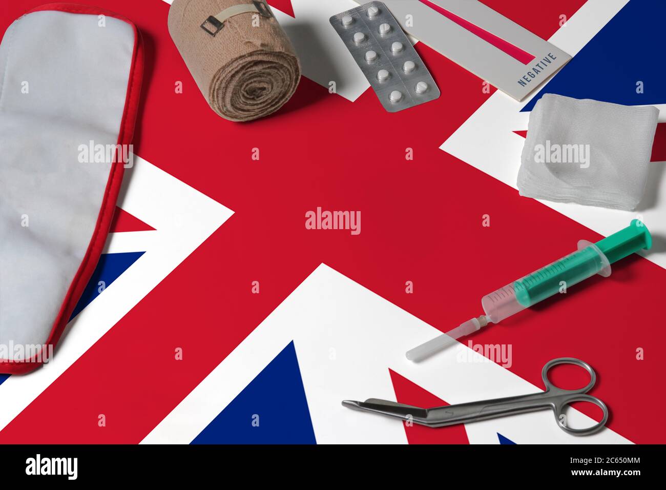 Britische Flagge mit Verbandskasten auf Holztisch Hintergrund. Nationales Gesundheitssystem Konzept, medizinisches Thema. Stockfoto
