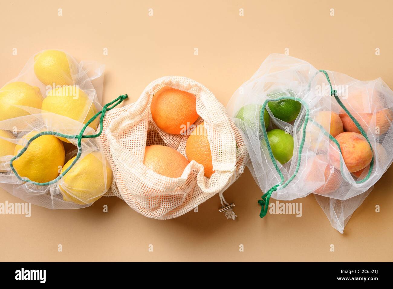 Früchte in wiederverwendbaren umweltfreundlichen Netzbeuteln auf gelb. Keine Verschwendung. Ökologisches Konzept. Umweltverschmutzung stoppen. Stockfoto