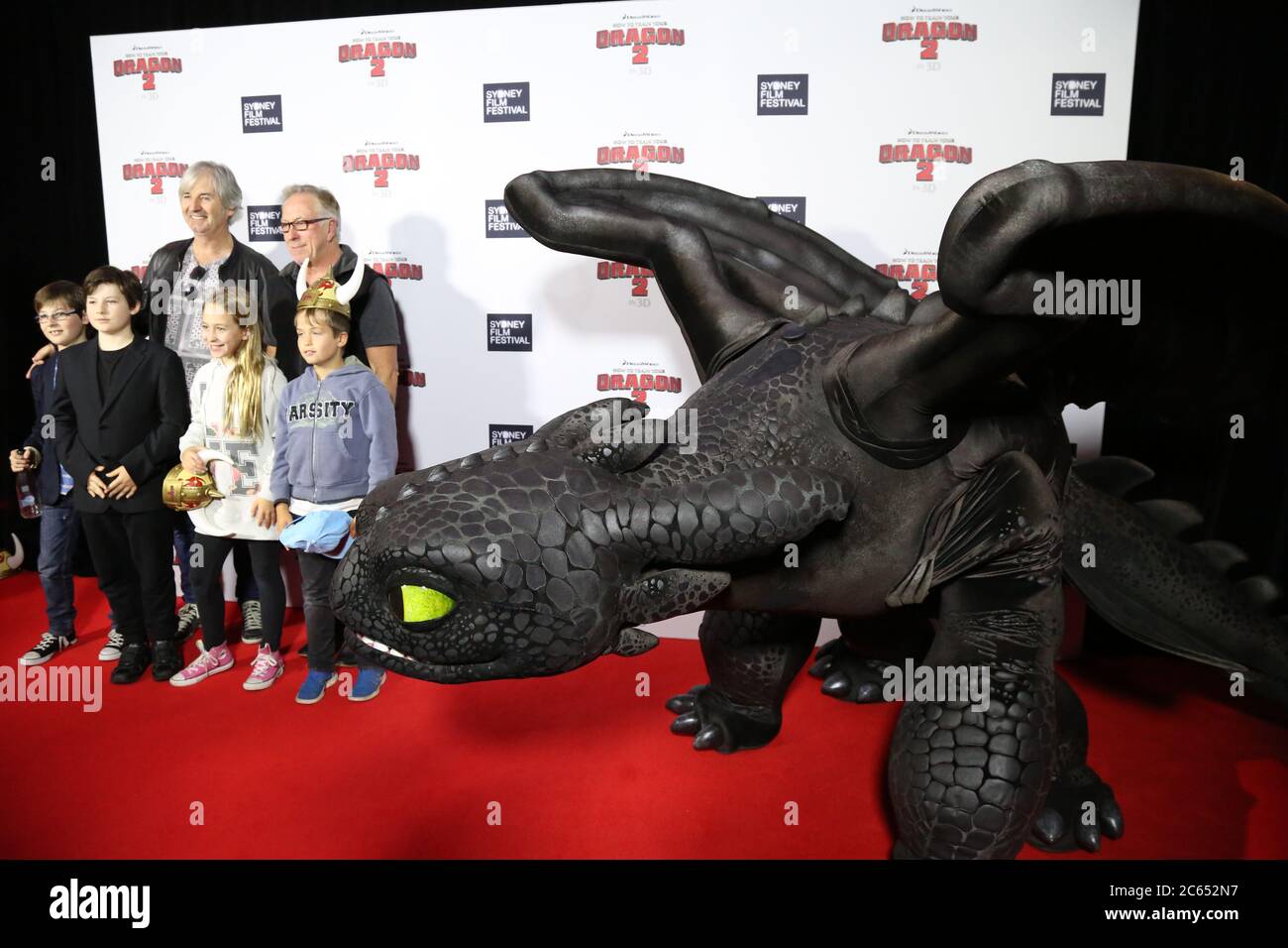 Schauspieler John Jarratt (Wolf Creek, Django Unchained, Australien) und Familienmitglieder kommen auf dem roten Teppich an, der mit dem Drachen Toothless an der aus abgebildet ist Stockfoto